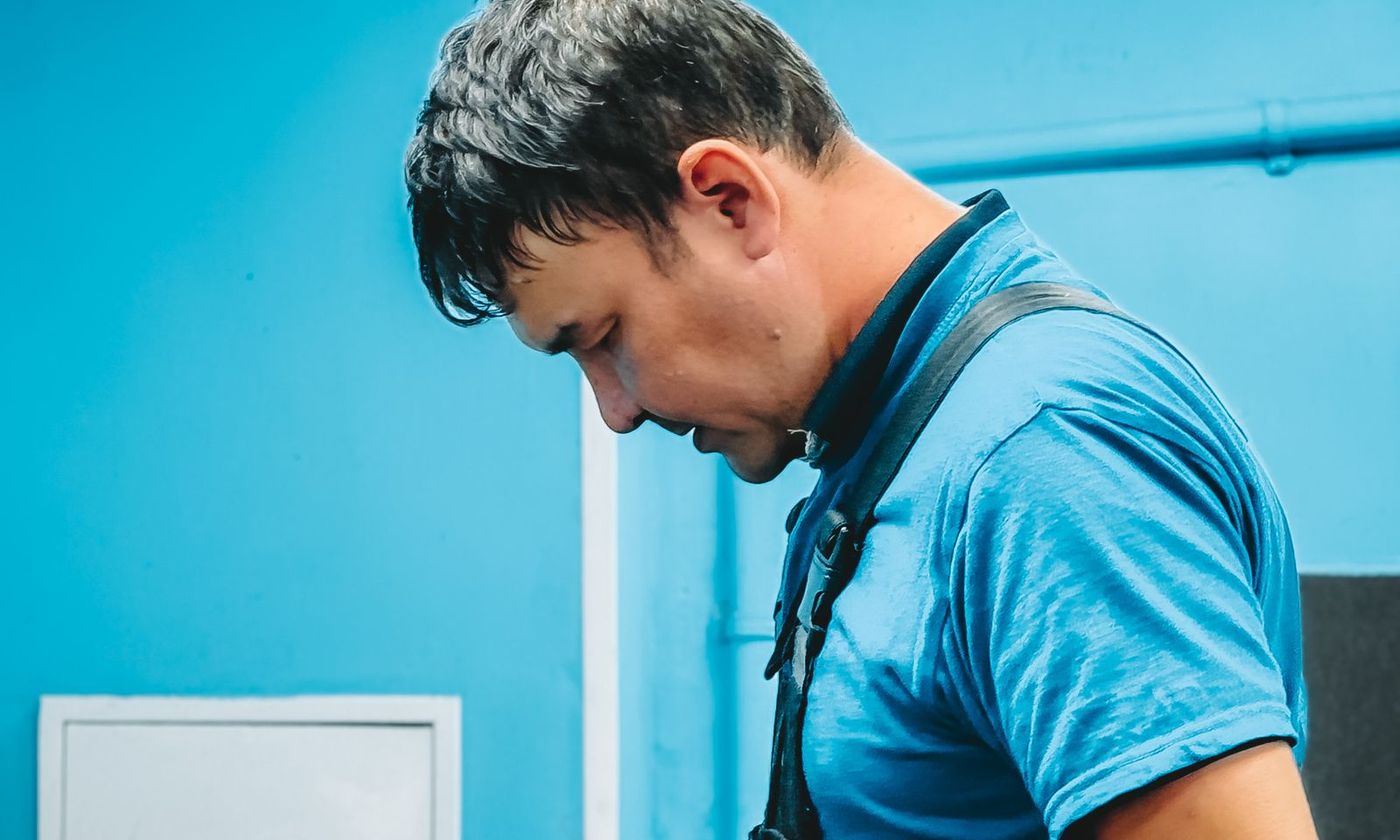 Technician in work overalls inspecting equipment during a service call